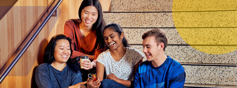 students on stairs looking at device